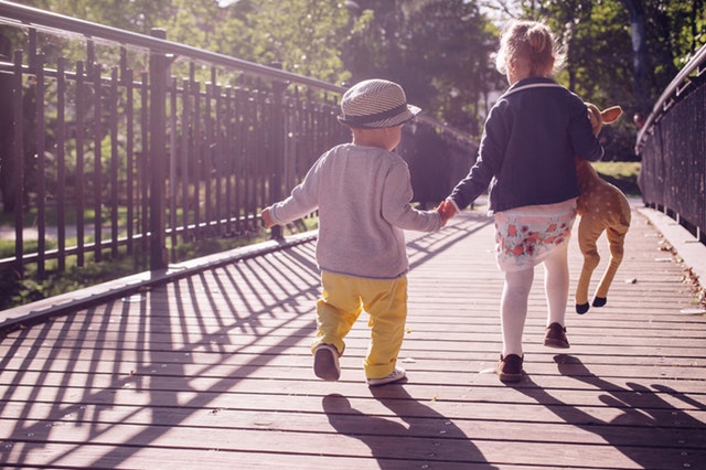 kluk s holčičkou běží přes most.jpg